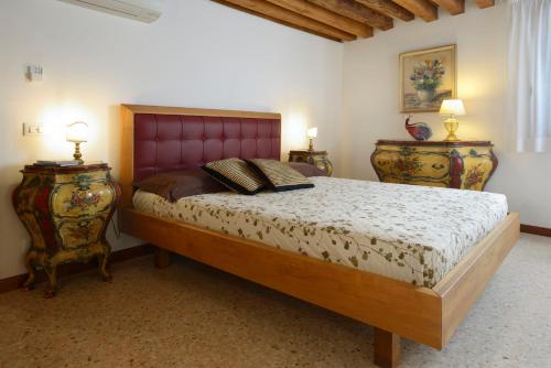 Schlafzimmer mit einem großen Bett mit einem roten Kopfteil in der Unterkunft Casa Fondamente Nuove in Venedig