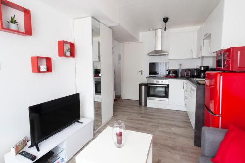 a kitchen with a red refrigerator and white cabinets at Chez Fred&Vir Arras in Arras