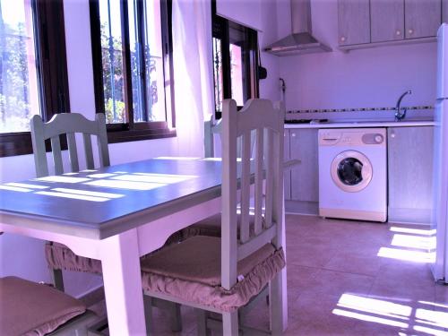 a kitchen with a table and chairs and a washing machine at Apartamentos Turisticos Trajano in Bolonia