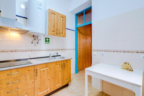 a kitchen with wooden cabinets and a sink at TREM - LOCATED IN OLD CITY - FARO in Faro