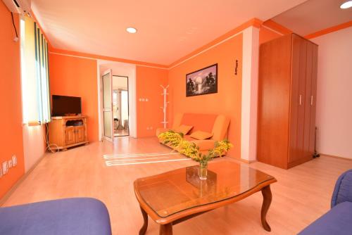 a living room with orange walls and a table at SeaSide House in Herceg-Novi