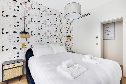 een slaapkamer met een groot wit bed en een muur bedekt met muzieknoten bij Pick A Flat's Apartment in Parc Monceau - Rue de Naples in Parijs