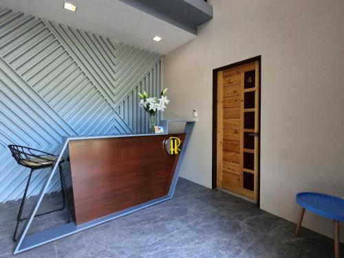 vestíbulo con escritorio, silla y puerta en Rold and Roub Home Suites powered by Cocotel, en Puerto Galera