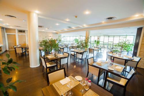 a restaurant with tables and chairs in a room at Best Western Plus Evreux Palais Des Congrès in Évreux