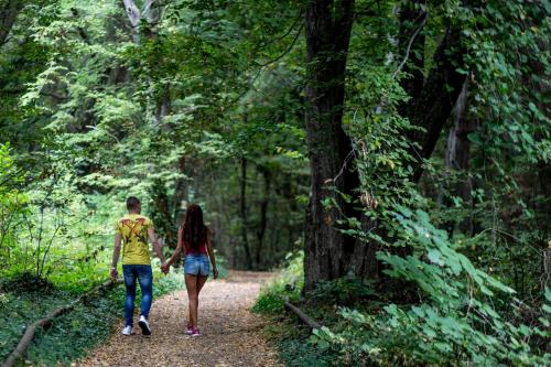 a man and woman walking down a path in the woods at Hotel Lilia in Golden Sands