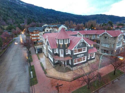 una casa grande con techo rojo en una calle en Horizonte Piedrabuena, en San Martín de los Andes