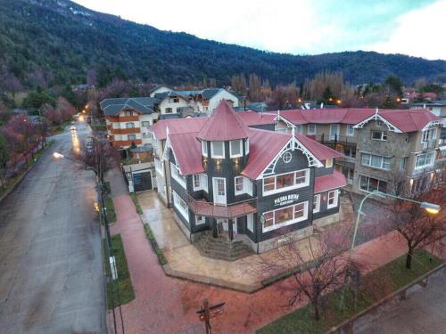 una casa grande con techo rojo en una calle en Horizonte Piedrabuena en San Martín de los Andes