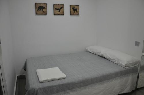 1 dormitorio con 1 cama con ordenador portátil en MODERNO NUEVO Luminoso WI-FI PLAZA DEL PILAR 2 en Zaragoza