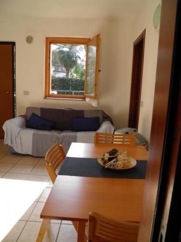 a living room with a table and a couch at MaremMare Tuscany Apartments in Principina a Mare