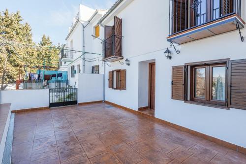 an empty courtyard of a house with white walls and windows at Fantástica Casa de 3 BR y 3 Baños - Casa de Relax- in Montefrío