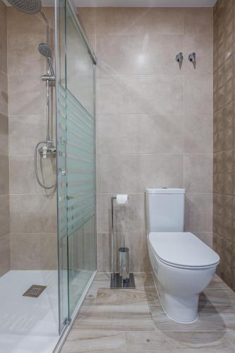 a bathroom with a toilet and a glass shower at Fantástica Casa de 3 BR y 3 Baños - Casa de Relax- in Montefrío
