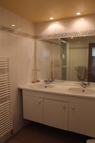 ein Badezimmer mit zwei Waschbecken und einem großen Spiegel in der Unterkunft LE CHARNOIS in Limelette