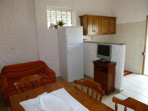 a kitchen with a table and a white refrigerator at Casa Pasqualina in Posada