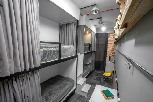 Habitación pequeña con literas y silla amarilla. en LOFT Hostel en Gyumri