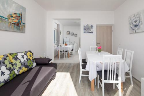 ein Wohnzimmer und ein Esszimmer mit einem Sofa und einem Tisch in der Unterkunft Apartments 20 meters from the beach in Jesenice