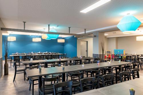 a large dining room with tables and chairs at a&o München Laim in Munich