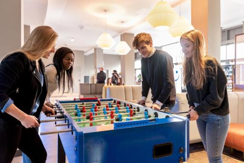 a group of people playing a game of foosball at a&o München Laim in Munich