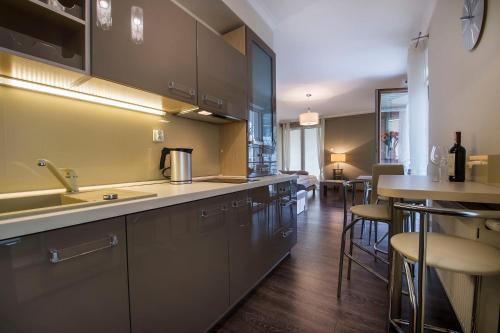 una cucina con un lavello e un bar con sgabelli di Apartamenty Feniks a Świnoujście