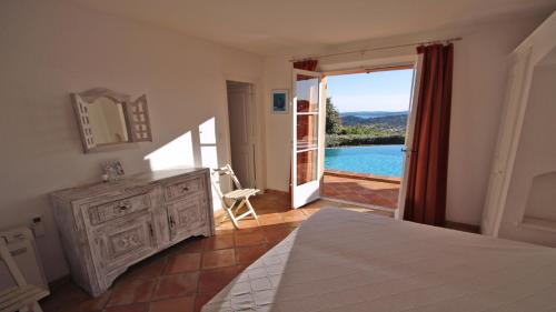 - une chambre avec un lit et une porte donnant sur une piscine dans l'établissement Villa Scénic Golf, à Sainte-Maxime