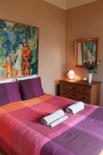 ein Schlafzimmer mit einem lila Bett mit zwei Handtüchern darauf in der Unterkunft LE CHARNOIS in Limelette