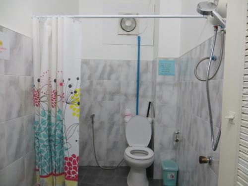 a bathroom with a toilet and a shower at La Maison Verte Hostel in Chiang Mai