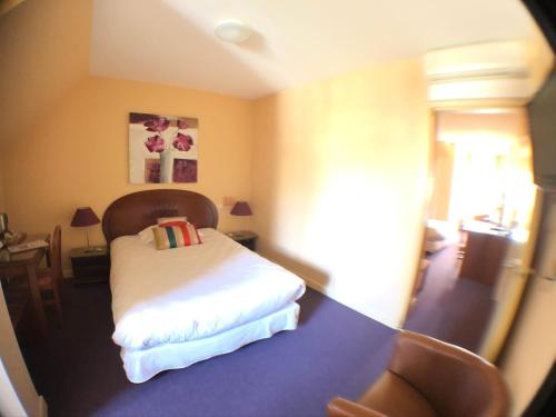 Auv'hôtel tesisinde bir odada yatak veya yataklar