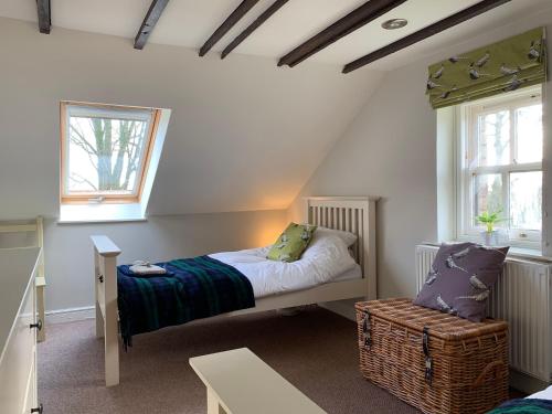 a small bedroom with a bed and a chair at Charming cottage with loch and hill views nr Edinburgh in Cobbinshaw