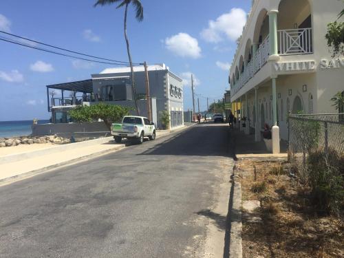 a white truck driving down a street next to a building at Heywoods Villa in Saint Peter