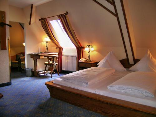 a bedroom with a bed and a desk and a window at Romantik Hotel Fürstenhof in Landshut