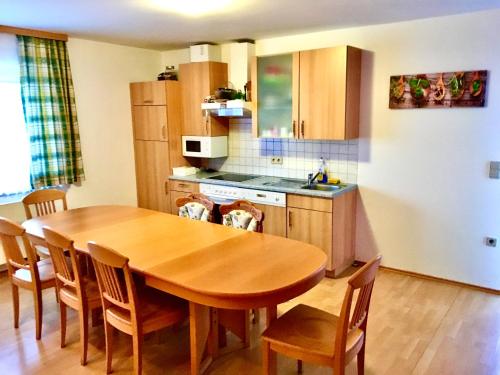 a kitchen with a wooden table and a table and chairs at Steirer Haus in Gamlitz