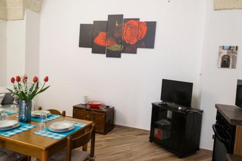 sala de estar con mesa y TV en La Strittula Salentina, en Poggiardo