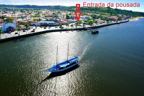 a blue boat in the water next to a city at Pousadinha- Melhor Localização in Porto Seguro