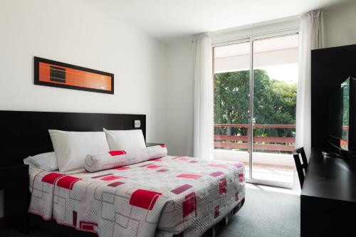 1 dormitorio con cama y ventana grande en Gran Hotel Fray Bentos, en Fray Bentos