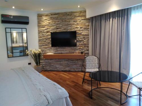 uma sala de estar com uma cama e uma televisão numa parede de tijolos em Noha Casa de Campo em Colón