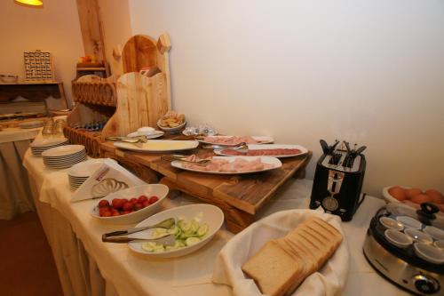 een tafel met borden en kommen met eten erop bij Adler ApartHotel in Moena