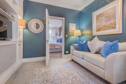 a living room with blue walls and a couch at Haven Cottage in Ambleside