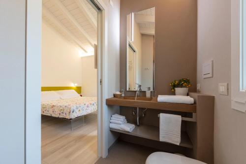 łazienka z umywalką, lustrem i łóżkiem w obiekcie ARIA Design B&B Levanto w mieście Levanto