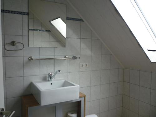 a white bathroom with a sink and a skylight at Gasthaus - Pension Am Buchberg in Mönchsdeggingen