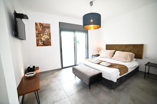 Un dormitorio con una cama, una mesa y una silla. en Royal Serenity Penthouse, en Tiberíades