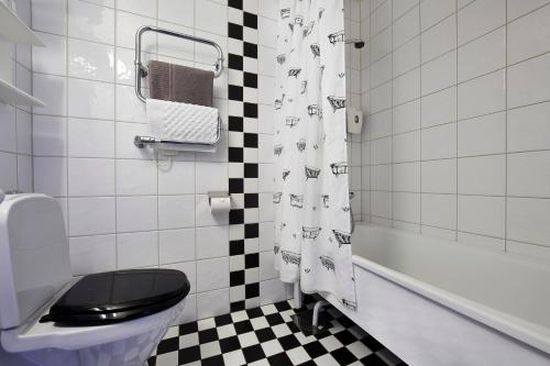 baño con cortina de ducha a cuadros en blanco y negro en First Hotel City Eskilstuna, en Eskilstuna