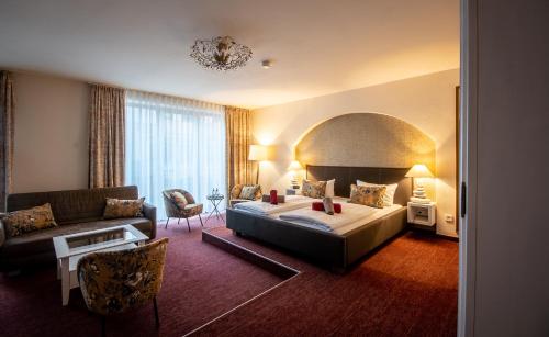a hotel room with a bed and a couch at Pension Donatus in Pirna