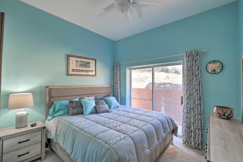Dormitorio azul con cama y ventana en Desert Gem with Patio and Grill, Near Oracle St Park! en Oracle