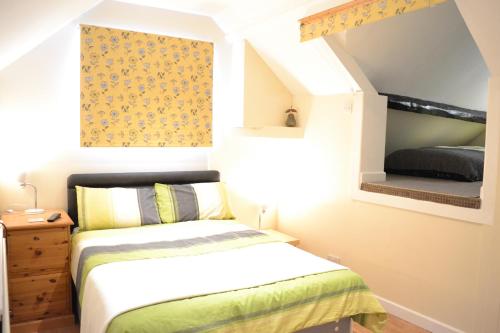 a small bedroom with a bed and a window at Halfway House in Great Malvern