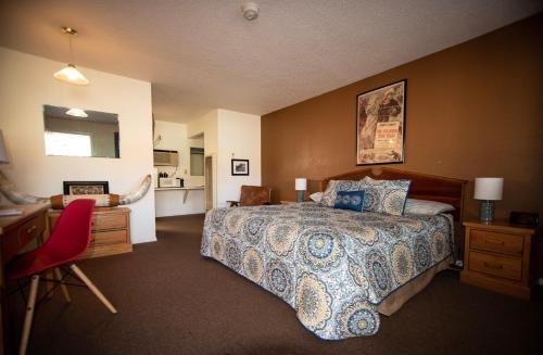 ein Hotelzimmer mit einem Bett, einem Schreibtisch und einer Küche in der Unterkunft Raton Pass Motor Inn in Raton