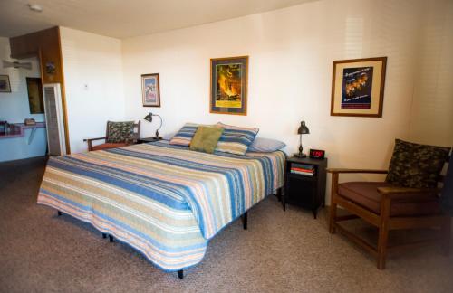 a bedroom with a bed and a chair at Raton Pass Motor Inn in Raton