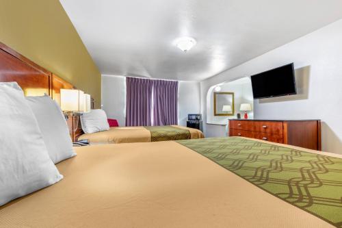 A bed or beds in a room at Rose City Inn & Suites