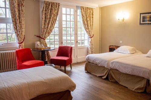 a hotel room with two beds and red chairs at Hostellerie et SPA de la Vieille Ferme in Criel-sur-Mer