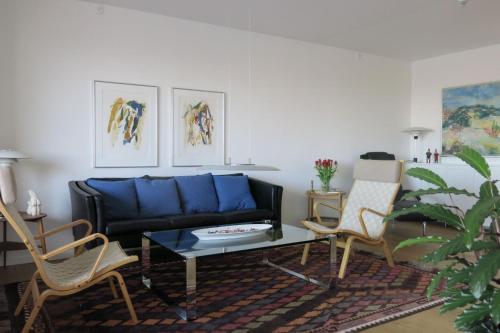 a living room with a blue couch and two chairs at ApartmentInCopenhagen Apartment 1442 in Copenhagen