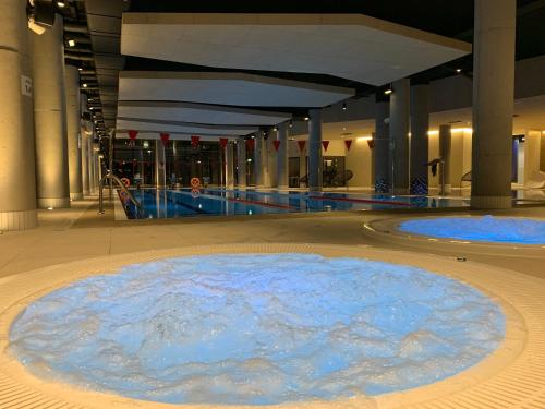 a large pool of blue water in a building at Seaside Park apartamenty prywatne z widokiem na morze in Kołobrzeg