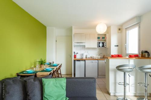 a living room with a couch and a kitchen at Amazing Cocoon in Bussy-Saint-Georges